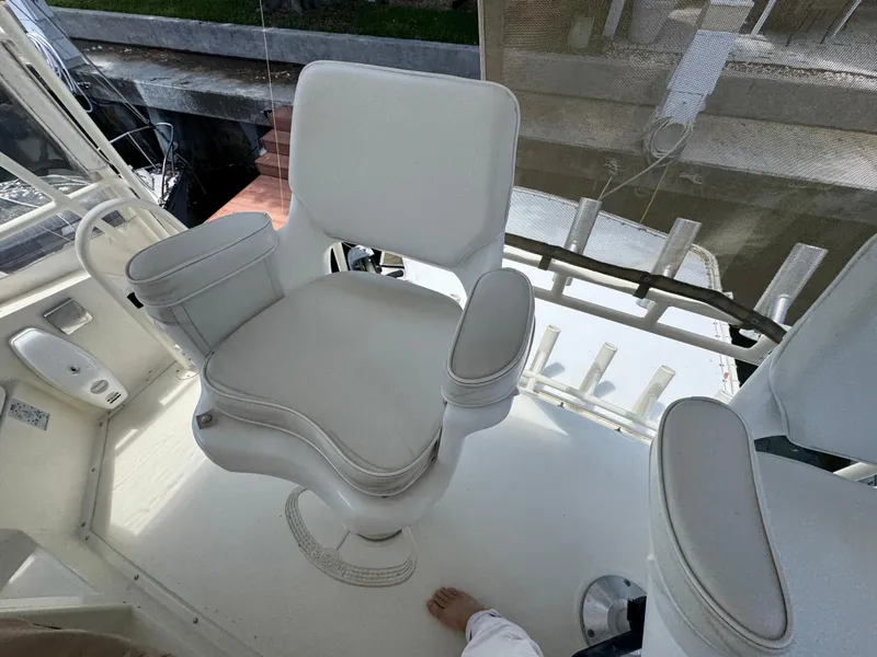Slide: The Image of Captain's chair on a 1990 Viking 35 boat, featuring white upholstery and armrests. - 47