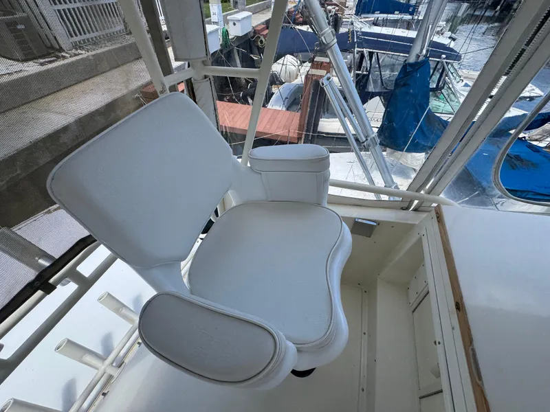 Slide: The Image of White captain's chair on a 1990 Viking 35 boat, overlooking marina. - 49