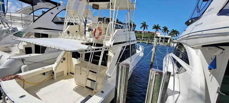 Slide: The Image of 1990 Viking 35 yacht docked at marina with clear blue sky and palm trees. - 5