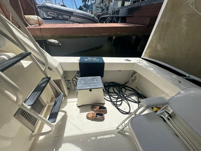 Slide: The Image of 1990 Viking 35 boat interior with seating, ladder, and docked inflatable boat. - 71