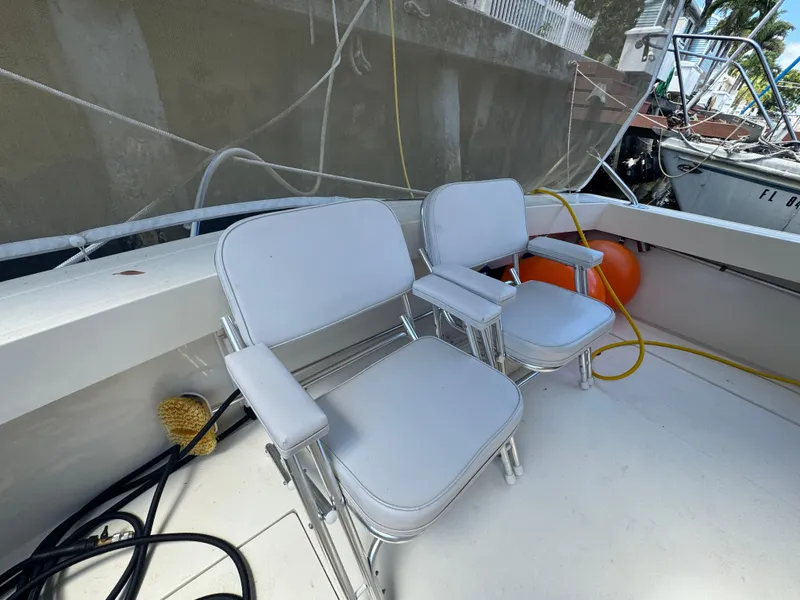 Slide: The Image of Two white chairs on a 1990 Viking 35 boat deck, with ropes and equipment nearby. - 72
