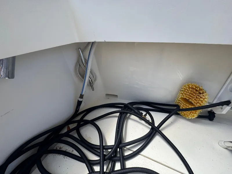 Slide: The Image of Tangled hoses and cleaning brush in a 1990 Viking 35 boat compartment. - 74