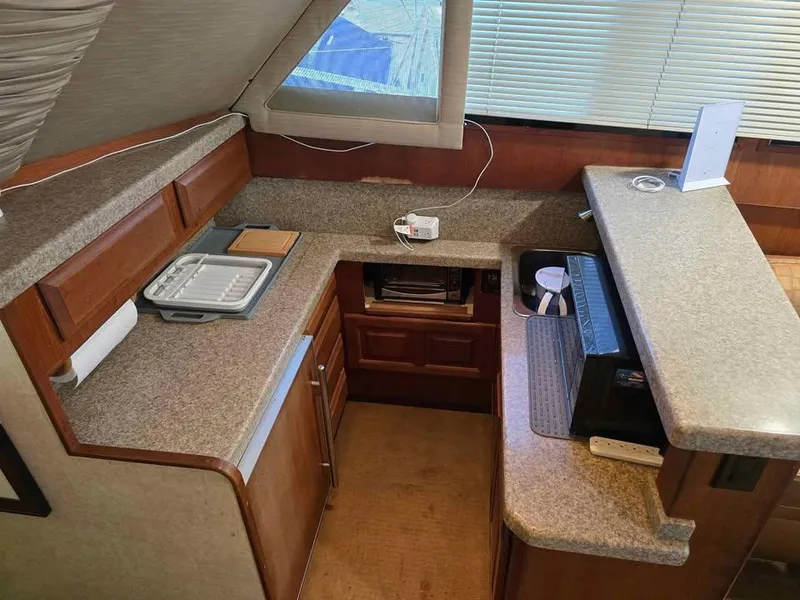 Slide: The Image of 1990 Viking 35 yacht kitchen with countertops, microwave, and storage cabinets. - 95