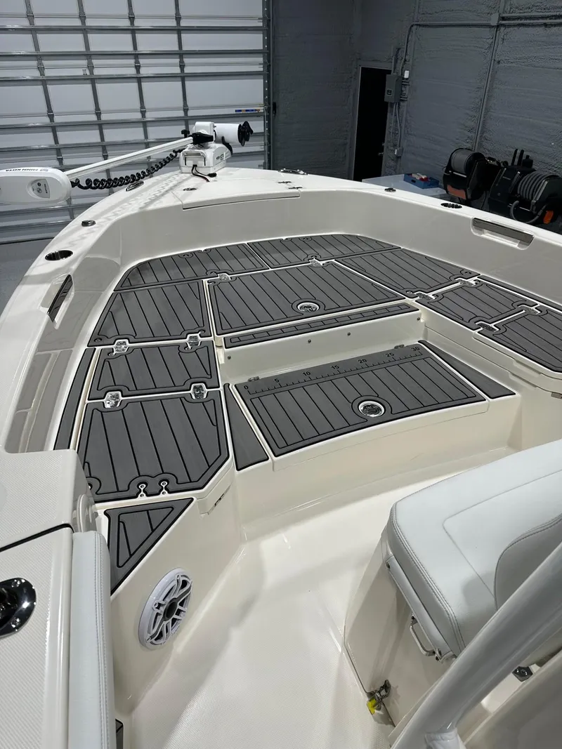 Slide: The Image of 2024 Pathfinder 2400 TRS boat interior with sleek deck design in a garage setting. - 10