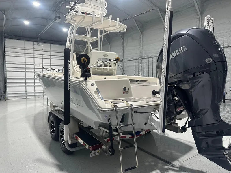 Slide: The Image of 2024 Pathfinder 2400 TRS boat in a garage with Yamaha outboard motor. - 2