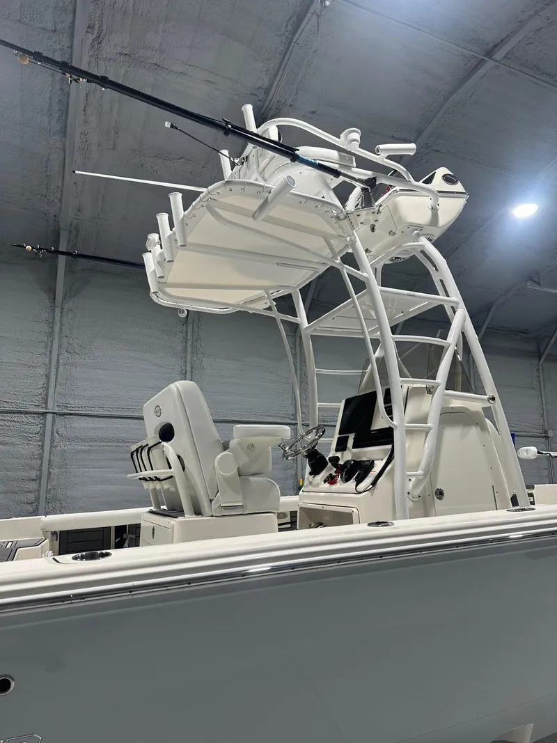 Slide: The Image of 2024 Pathfinder 2400 TRS boat with elevated helm and fishing equipment in a warehouse. - 4