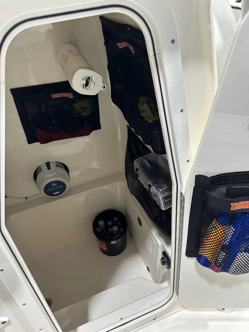 Slide: The Image of 2024 Pathfinder 2400 TRS boat storage compartment with organized gear and accessories. - 5