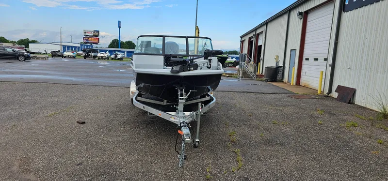 Slide: The Image of 2024 G3 Sportsman 2100 boat on trailer in parking lot near industrial building. - 2