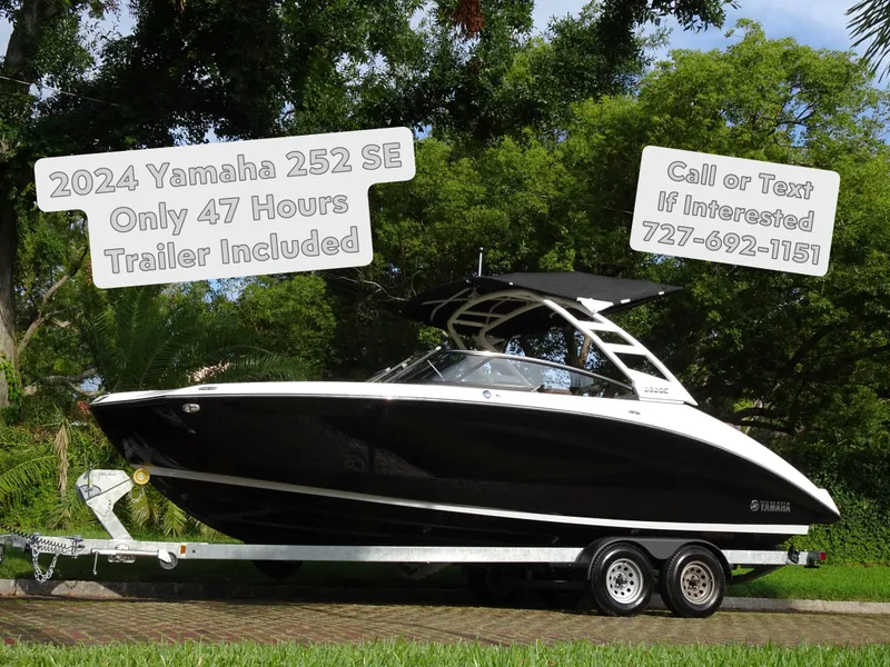 The Image of 2024 Yamaha 252SE boat on trailer, black and white, for sale with contact info. - 0