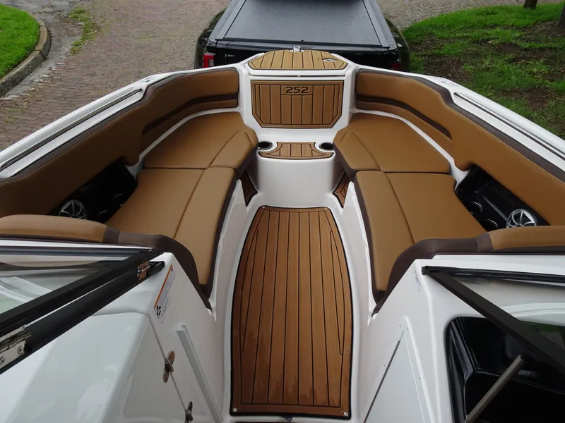 Slide: The Image of 2024 Yamaha Boats 252SE interior with tan seating and wood-style flooring. - 11