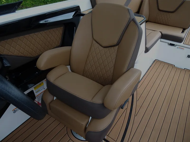 Slide: The Image of 2024 Yamaha Boats 252SE captain's chair with tan upholstery and diamond stitching. - 18