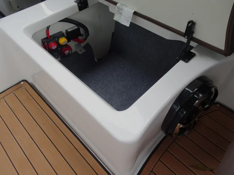 Slide: The Image of 2024 Yamaha Boats 252SE storage compartment with battery access and teak flooring. - 23