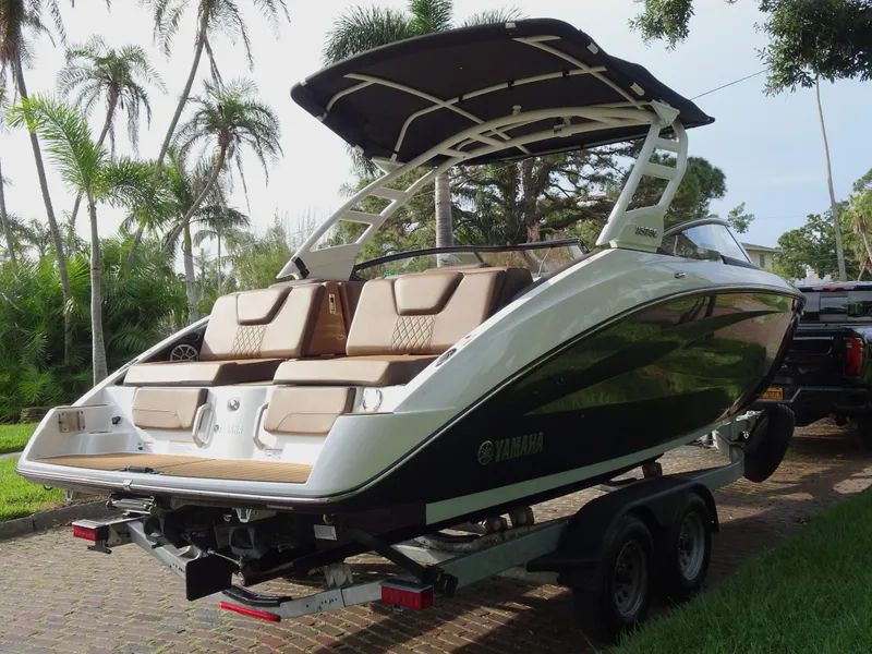 Slide: The Image of 2024 Yamaha Boats 252SE on trailer, sleek design, palm trees in background. - 5
