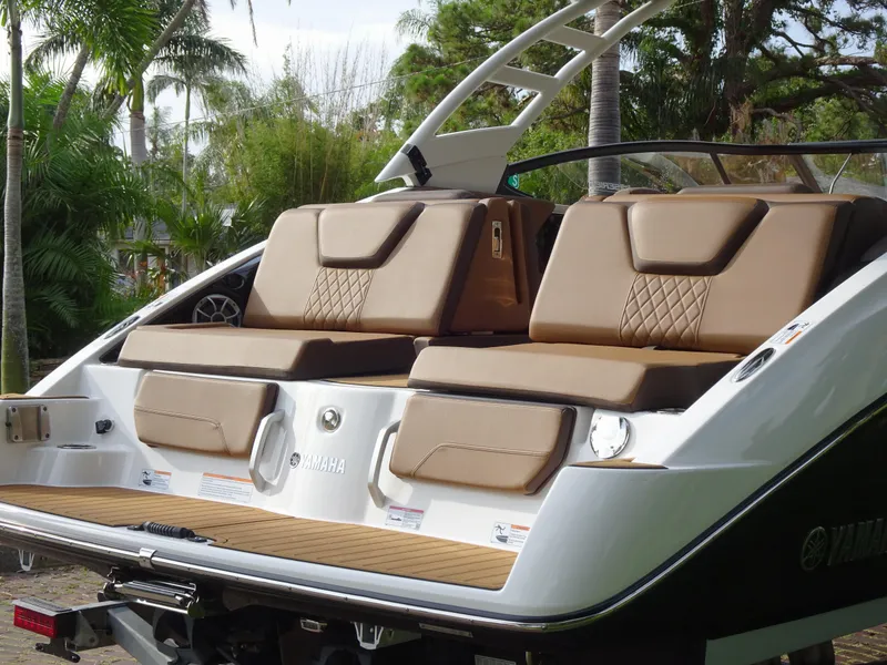 Slide: The Image of 2024 Yamaha Boats 252SE with luxurious seating and sleek design in a tropical setting. - 7