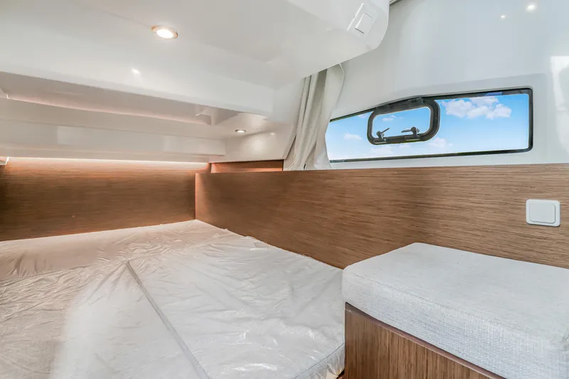 Slide: The Image of 2024 Jeanneau NC1095 Fly cabin interior with modern wood finish and window view. - 13