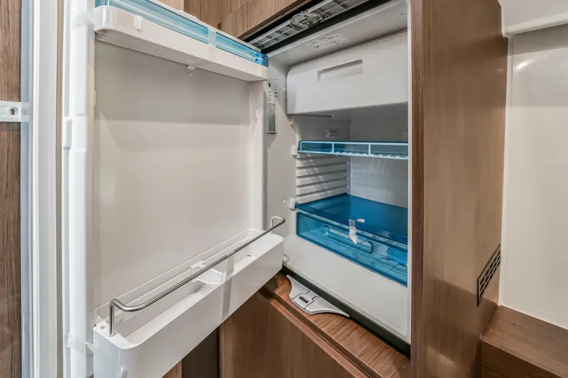 Slide: The Image of Open refrigerator inside 2024 Jeanneau NC1095 Fly boat, showcasing modern interior design. - 14