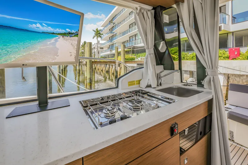 Slide: The Image of Modern kitchen on 2024 Jeanneau NC1095 Fly yacht with scenic view and TV display. - 16
