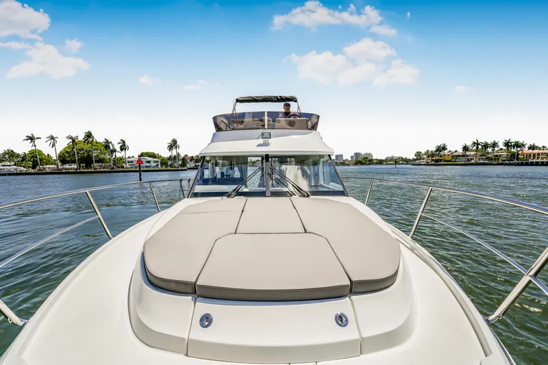 Slide: The Image of 2024 Jeanneau NC1095 Fly yacht cruising on a sunny day, featuring spacious deck and flybridge. - 25