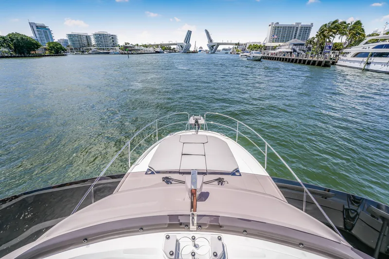 Slide: The Image of 2024 Jeanneau NC1095 Fly yacht cruising towards an open drawbridge in a city harbor. - 28