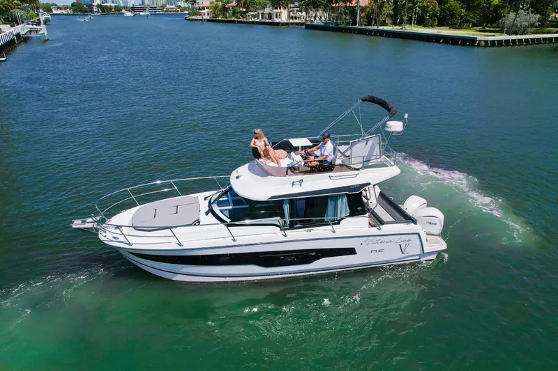 Slide: The Image of 2024 Jeanneau NC1095 Fly cruising on a scenic waterway with passengers enjoying the view. - 3