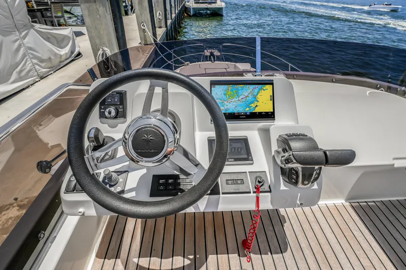 Slide: The Image of 2024 Jeanneau NC1095 Fly helm with navigation display and controls, docked by the water. - 33