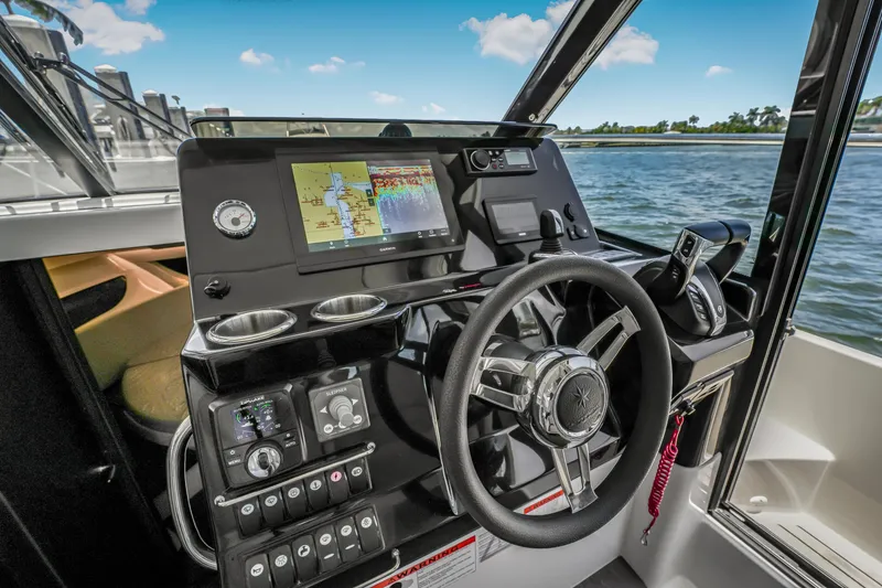 Slide: The Image of 2024 Jeanneau NC1095 Fly helm with navigation display and controls, overlooking water. - 37