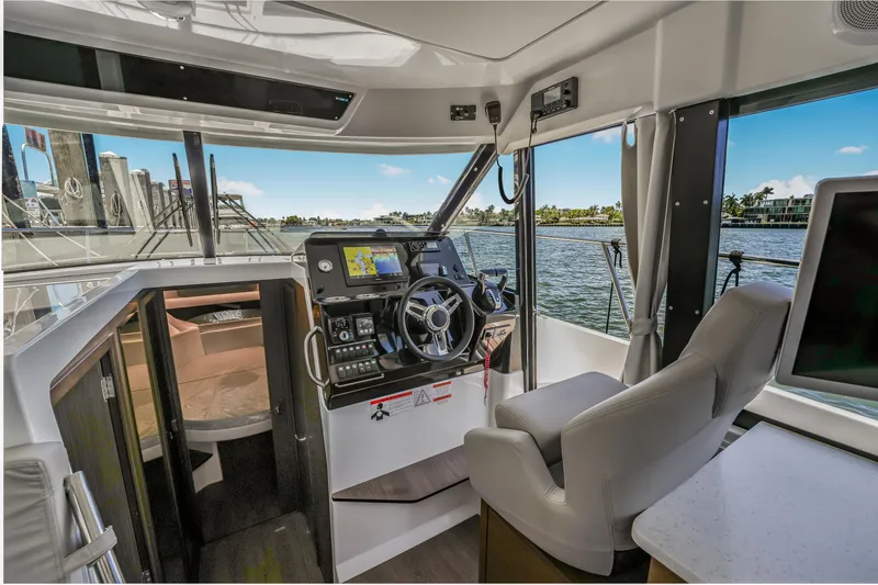 Slide: The Image of 2024 Jeanneau NC1095 Fly helm with modern controls and waterfront view. - 38