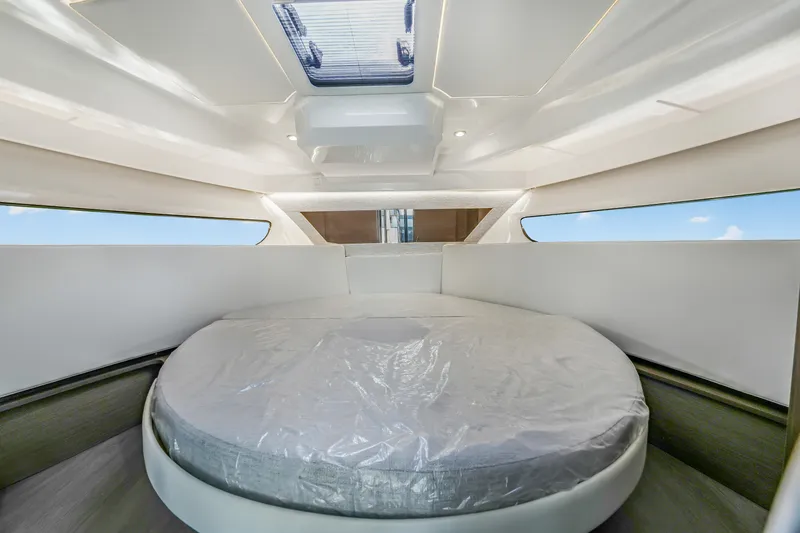 Slide: The Image of 2024 Jeanneau NC1095 Fly cabin interior with round bed and skylight. - 9