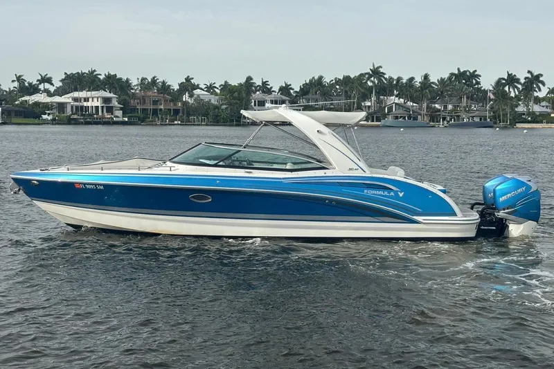 The Image of 2020 Formula 310 Bowrider boat with blue exterior on a calm lake. - 0