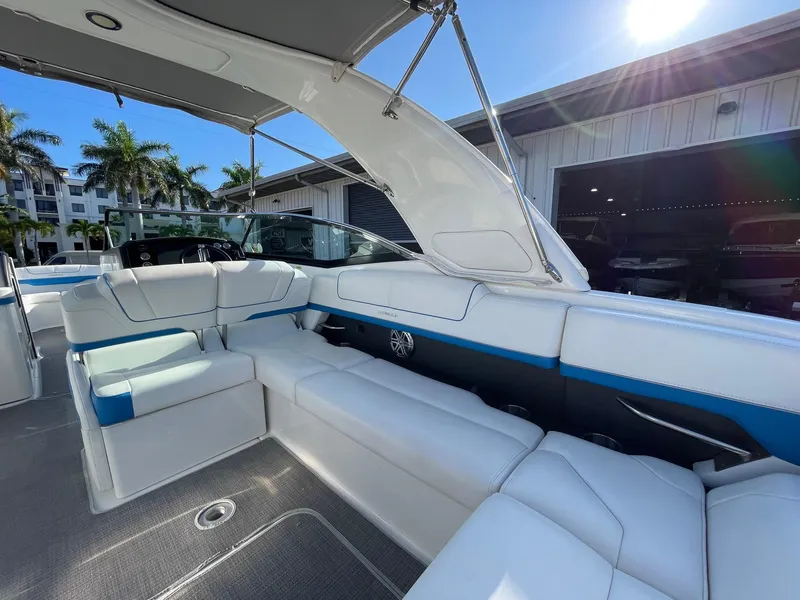 Slide: The Image of 2020 Formula 310 Bowrider interior with white seating, blue accents, and sunny outdoor setting. - 10