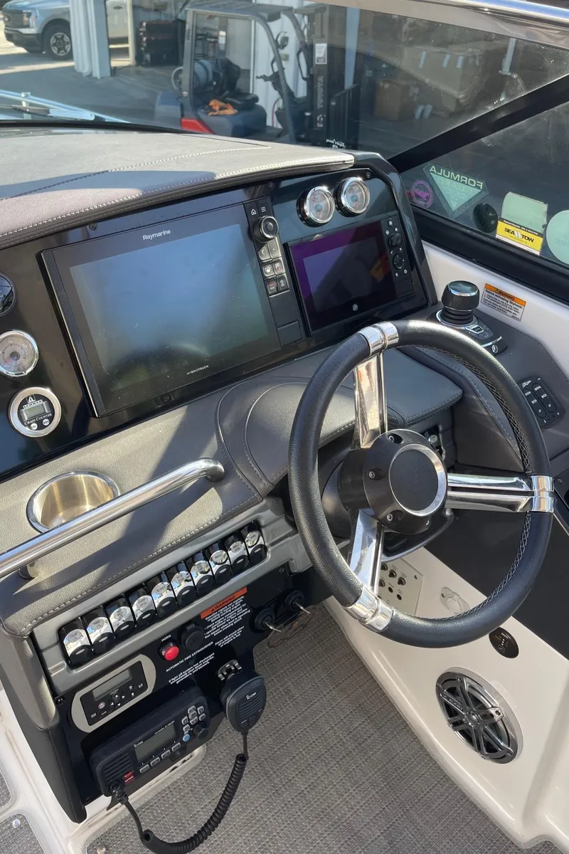Slide: The Image of 2020 Formula 310 Bowrider helm with modern controls and navigation displays. - 11