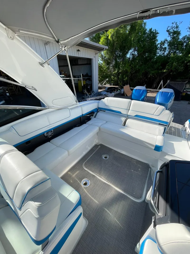 Slide: The Image of 2020 Formula 310 Bowrider interior with white and blue seating under canopy. - 19