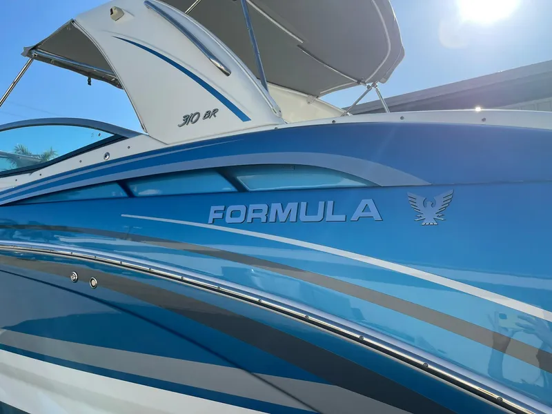 Slide: The Image of 2020 Formula 310 Bowrider boat with sleek blue design and branding. - 6