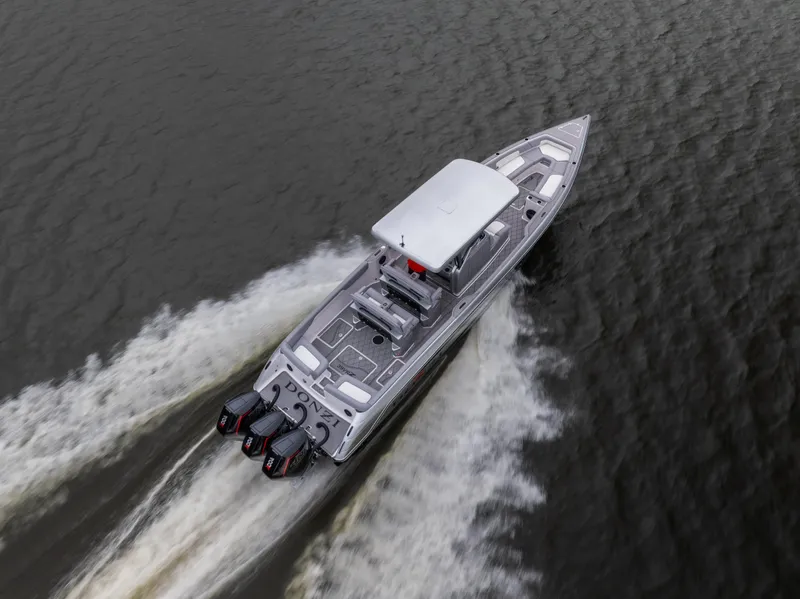 Slide: The Image of 2025 Donzi 39 VRZ boat cruising on water with triple outboard engines. - 13