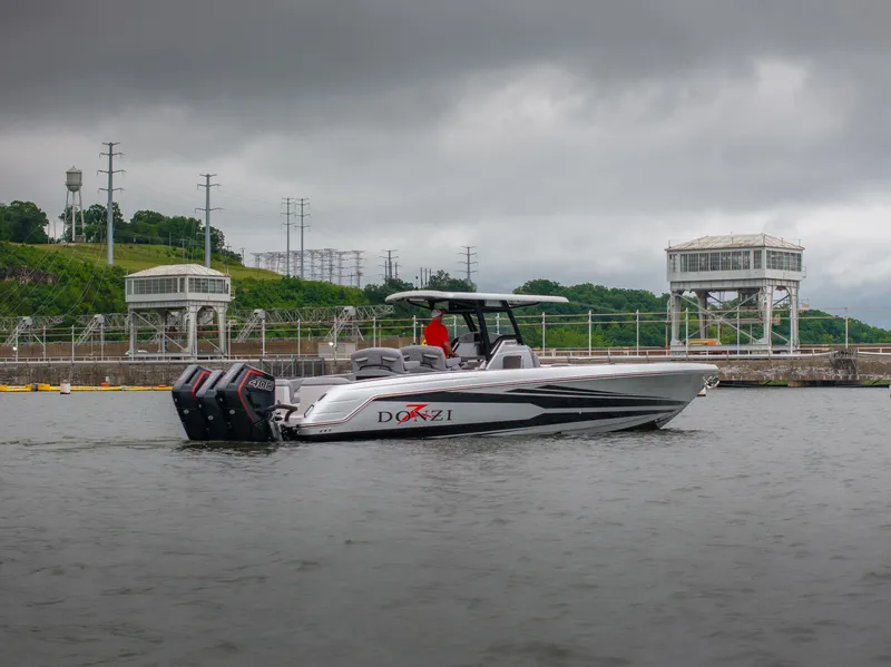 Slide: The Image of 2025 Donzi 39 VRZ boat on water, overcast sky, industrial background. - 2