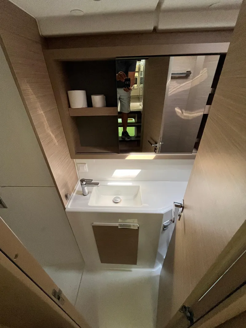 Slide: The Image of 2023 Lagoon 40 yacht bathroom with modern sink and wooden cabinetry. - 26