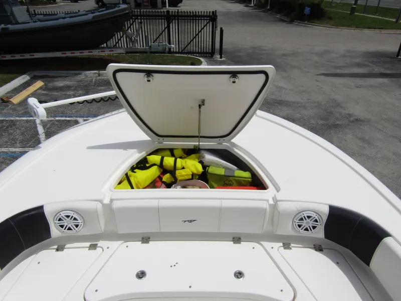 Slide: The Image of 2021 Tidewater 2700 Carolina Bay boat with open storage compartment and life jackets. - 12