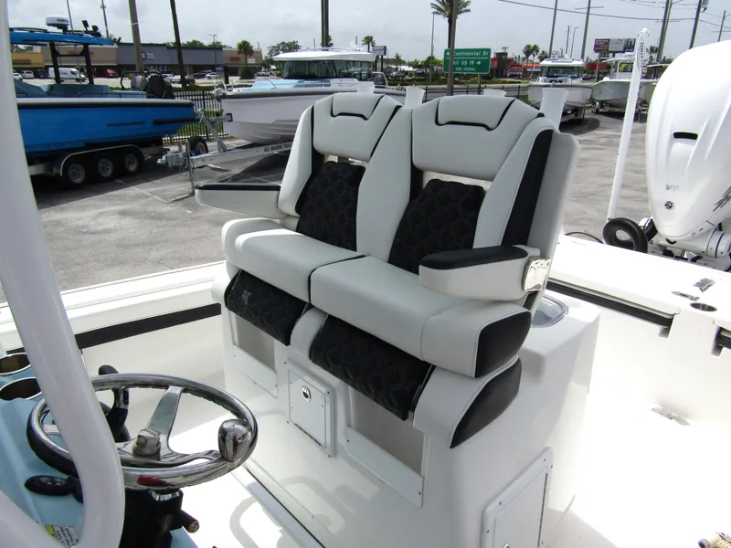 Slide: The Image of 2021 Tidewater 2700 Carolina Bay boat with dual cushioned seats and steering wheel. - 22