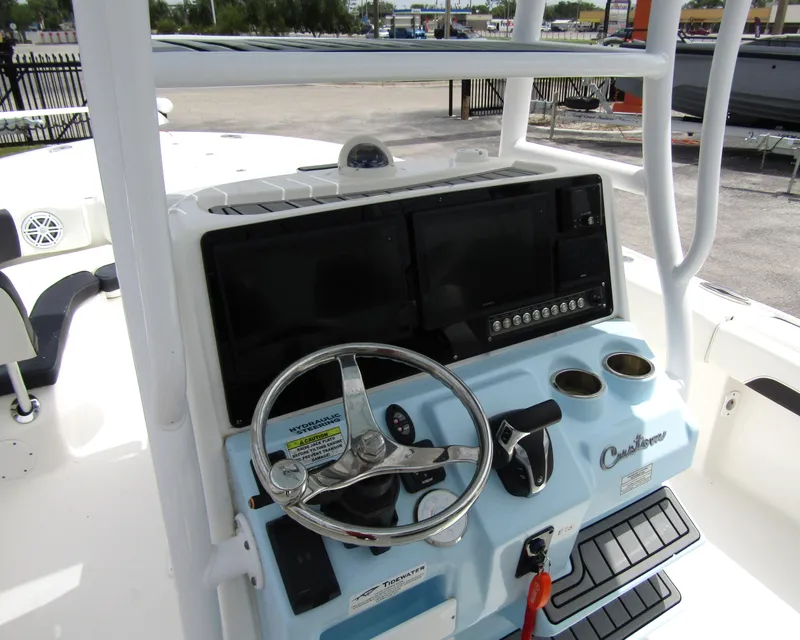 Slide: The Image of 2021 Tidewater 2700 Carolina Bay boat dashboard with steering wheel and controls. - 23