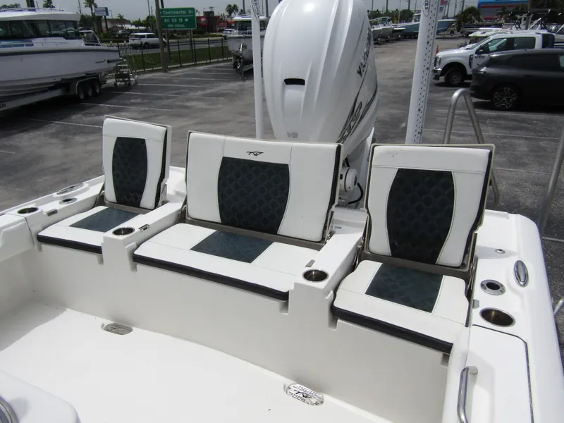 Slide: The Image of 2021 Tidewater 2700 Carolina Bay boat seating area with cushioned seats and cup holders. - 37