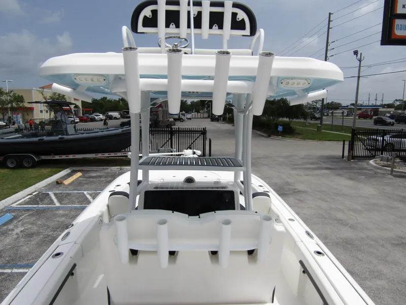 Slide: The Image of 2021 Tidewater 2700 Carolina Bay boat with T-top and rod holders in a parking lot. - 43