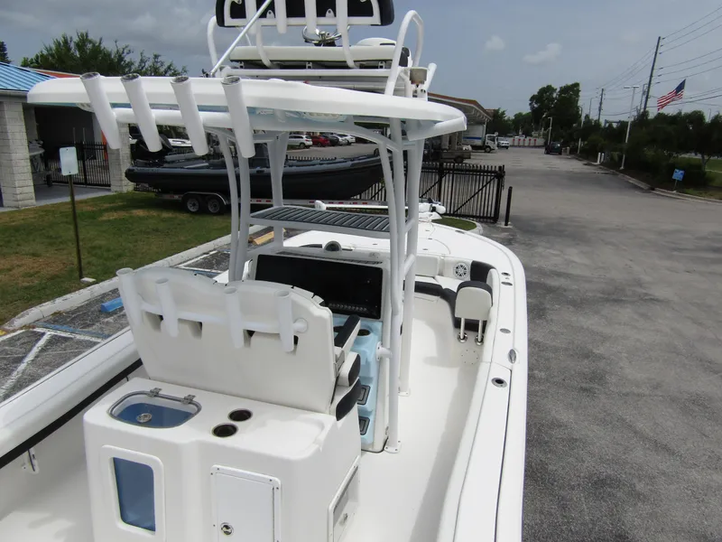 Slide: The Image of 2021 Tidewater 2700 Carolina Bay boat with T-top and seating, parked on a paved area. - 44