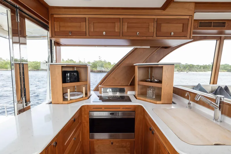 Slide: The Image of Luxurious 2026 Sabre 58 Salon Express yacht kitchen with wood cabinetry and modern appliances. - 4