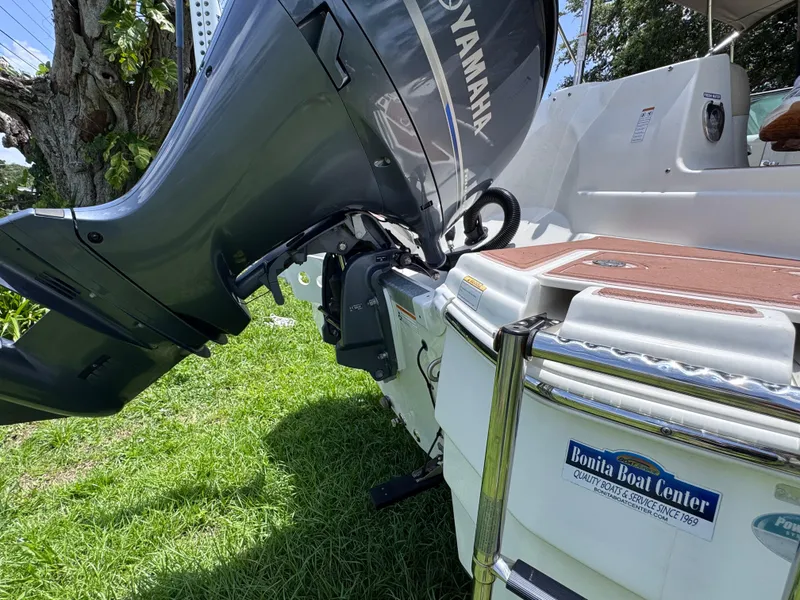 Slide: The Image of 2018 NauticStar DC 243 Sport Deck boat with Yamaha outboard motor on grass. - 12