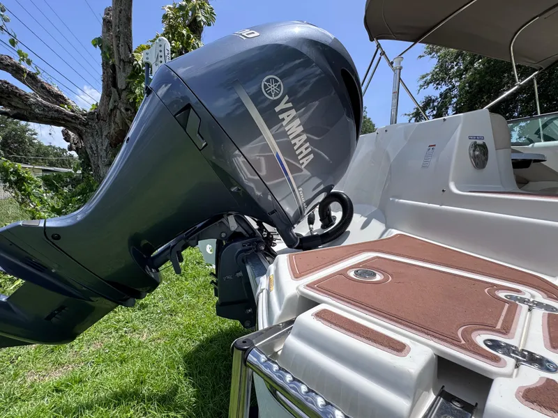 Slide: The Image of 2018 NauticStar DC 243 Sport Deck with Yamaha outboard motor, parked on grass. - 13