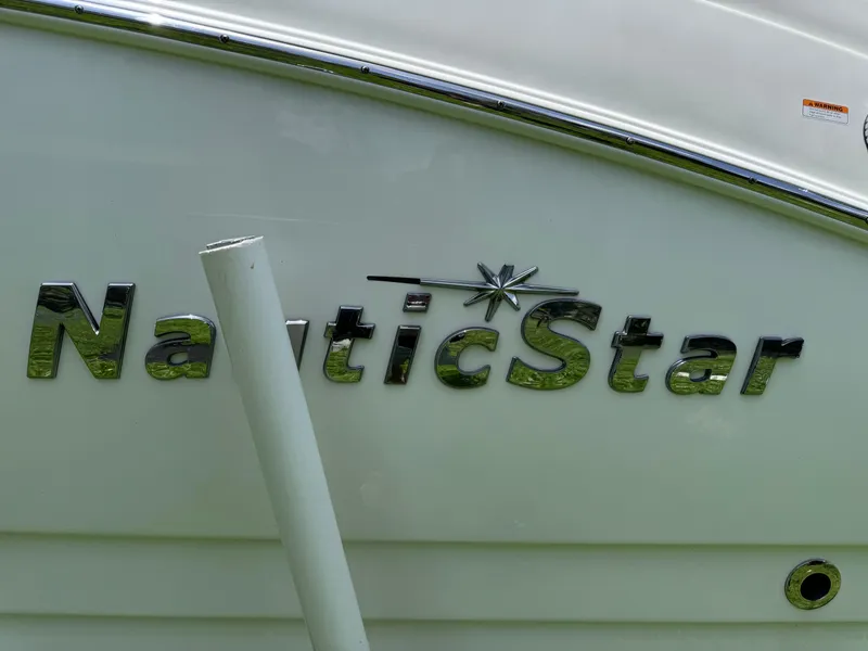 Slide: The Image of NauticStar DC 243 Sport Deck 2018 boat logo on white hull. - 20
