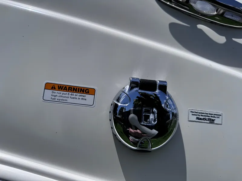 Slide: The Image of 2018 NauticStar DC 243 Sport Deck fuel cap with warning label. - 22