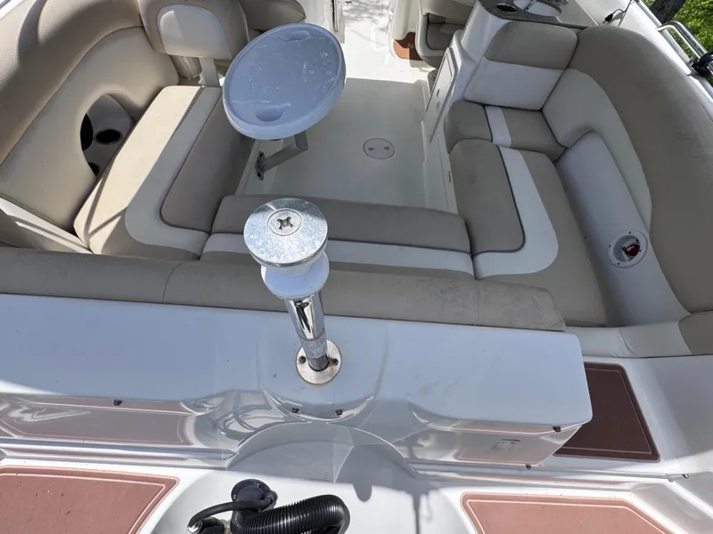 Slide: The Image of 2018 NauticStar DC 243 Sport Deck interior with beige seating and table mount. - 24