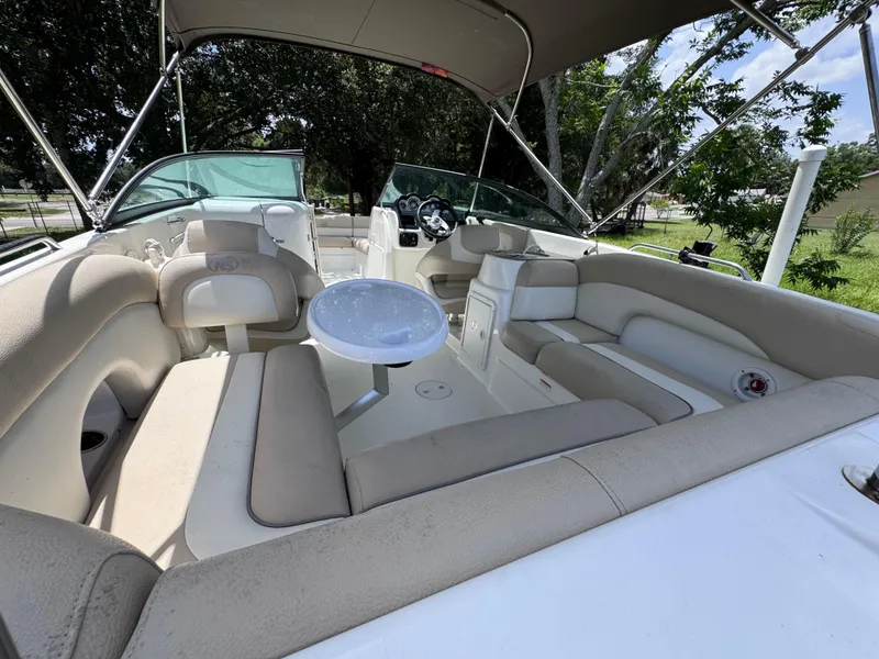 Slide: The Image of 2018 NauticStar DC 243 Sport Deck boat interior with seating and table under canopy. - 26
