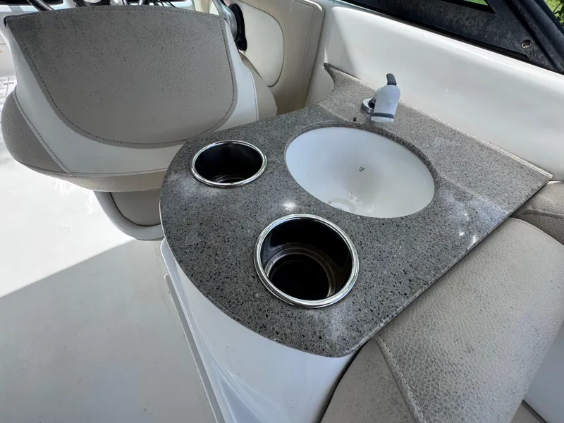 Slide: The Image of Interior of 2018 NauticStar DC 243 Sport Deck with sink and cup holders. - 28